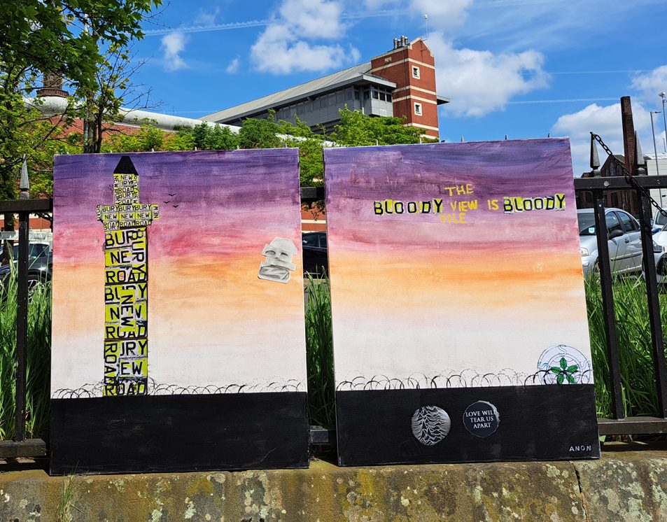 Two sunset-toned canvases: a &lsquo;Bury New Road&rsquo; text tower over barbed wire, and &lsquo;The Bloody View is Bloody Vile&rsquo; with a Joy Division motif