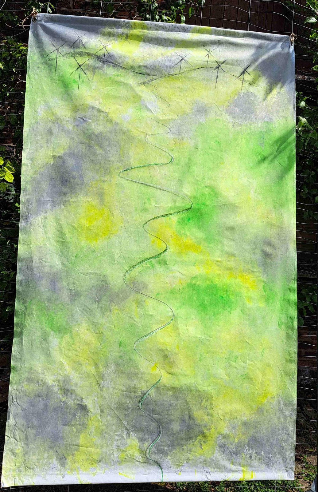 Turbines of Your Mind — a hand-dyed green and yellow fabric hanging with star-like marks and a winding stitched line